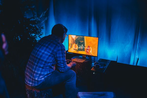 A person sits on a stump while playing Firewatch